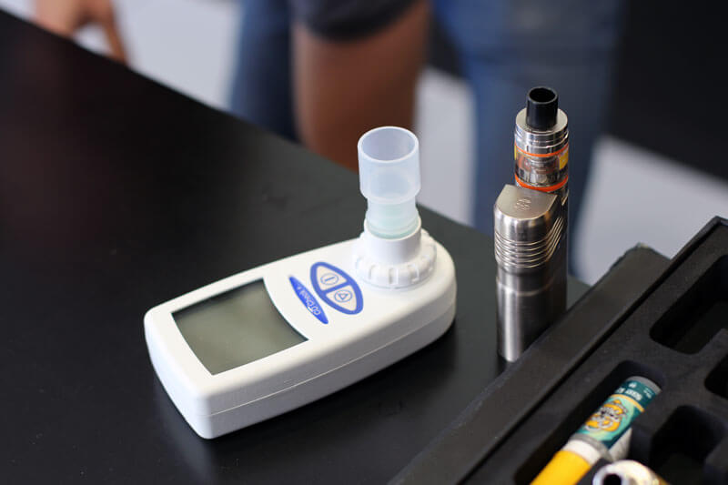 testeur de monoxyde de carbone à côté d'une cigarette électronique